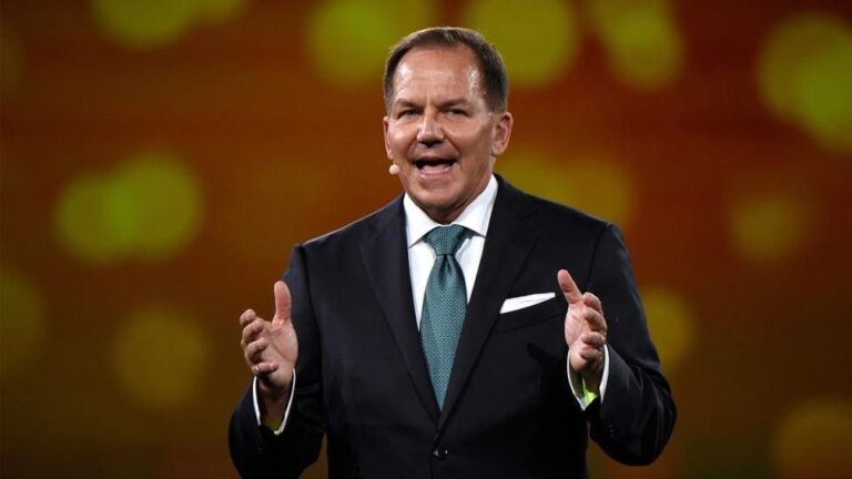 Milliardär Paul Tudor Jones vor einem Bitcoin-Logo und einem roten Aktien-Chart