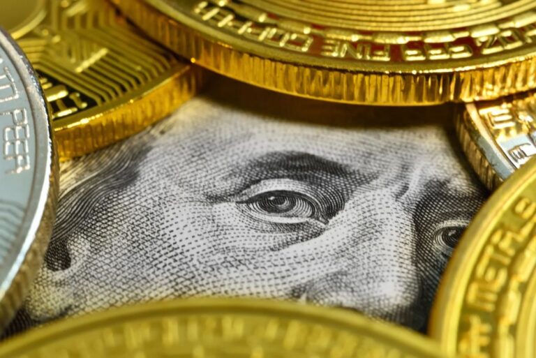 Physische Bitcoin-Münze vor einem absteigenden roten Kurs-Chart, symbolisiert einen Marktverkauf.