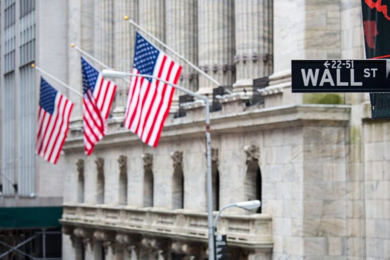 Bitcoin-Münze vor einem ansteigenden Kurs-Chart und US-Dollar-Symbolen
