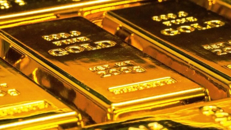 Fallender roter Kurs-Chart vor einer physischen Bitcoin-Münze sowie Gold- und Silbermünzen