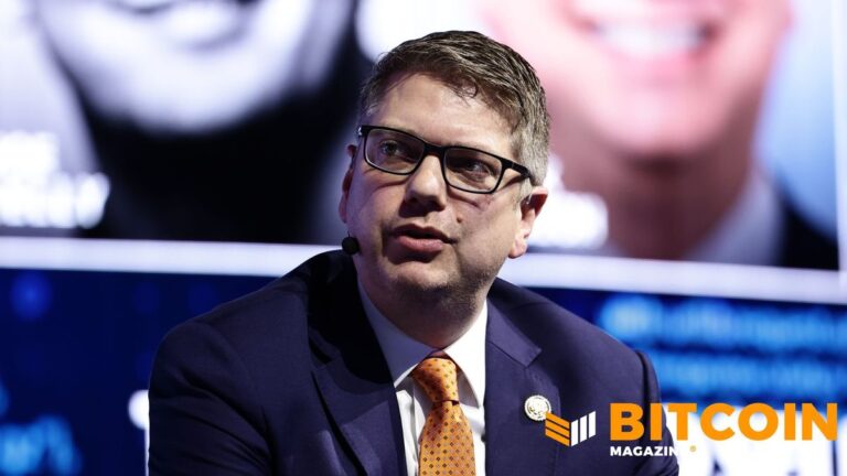 Porträt des US-Politikers Nick Begich neben einer physischen Bitcoin-Münze