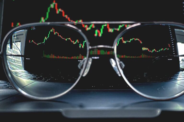Bitcoin-Münze vor einem steigenden Kurs-Chart und einer stilisierten Weltkarte.