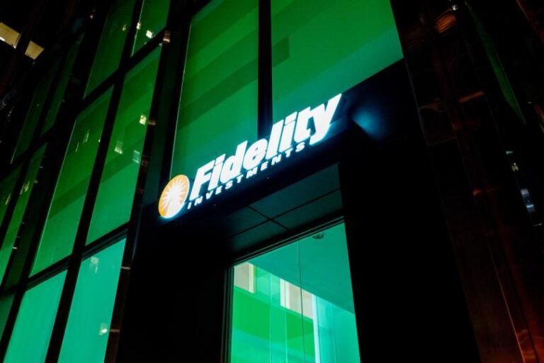 Das Logo des Finanzdienstleisters Fidelity neben einer digitalen Krypto-Münze