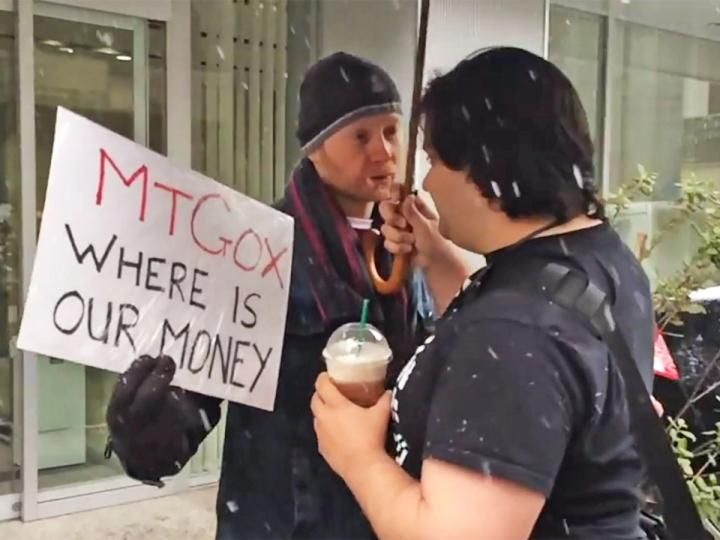 Eine physische Bitcoin-Münze vor einem sinkenden Kurs-Chart und dem Mt. Gox Logo