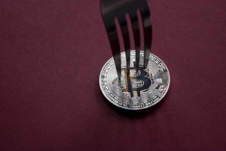 Eine physische Bitcoin-Münze vor einem dunklen Hintergrund mit fallenden roten Datenströmen