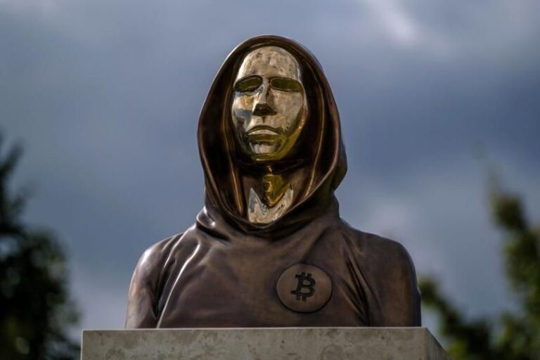 Eine silberne Bitcoin-Münze vor einem futuristischen Quantencomputer