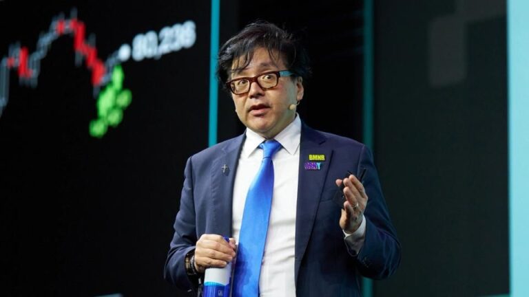 Tom Lee spricht auf einer Konferenzbühne vor einem Ethereum-Symbol