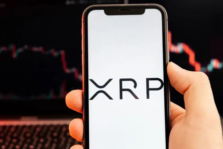 Eine physische Ripple-Münze (XRP) vor einem roten Kurs-Chart, der Stagnation symbolisiert