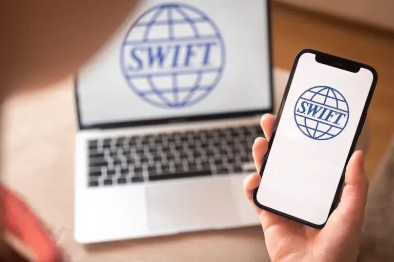 Ripple-Logo und SWIFT-Schriftzug auf einem digitalen Hintergrund mit internationalen Finanzströmen