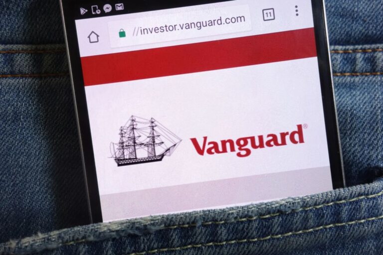 Das Logo des Vermögensverwalters Vanguard neben einer Bitcoin-Münze und einem aufwärts gerichteten Kurs-Chart.