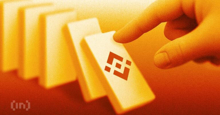 Smartphone mit Binance-App vor einem Warnschild und EU-Flaggen im Hintergrund