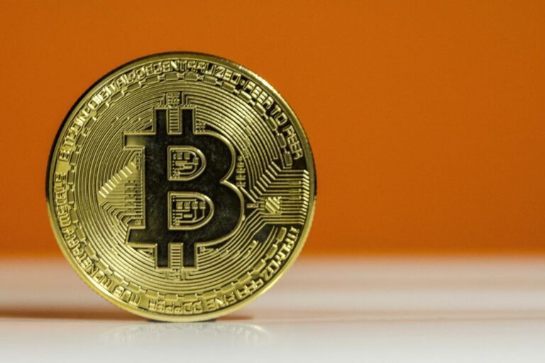 Porträt eines Bloomberg-Analysten vor einem fallenden roten Bitcoin-Kurs-Chart