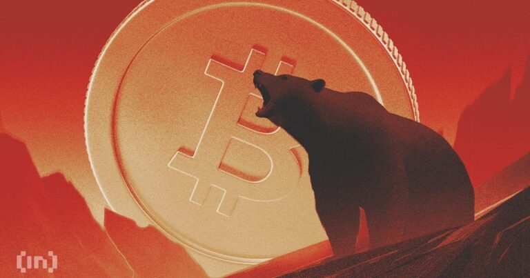 Ein fallender roter Kurs-Chart über einer physischen Bitcoin-Münze vor dunklem Hintergrund