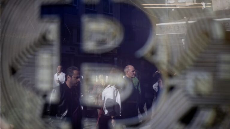 Goldene Bitcoin-Münze vor einem Kurschart und US-Dollar-Symbolen im Hintergrund