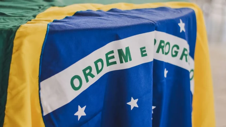 Symbolbild für Krypto-Regulierung in Brasilien mit einer Bitcoin-Münze vor der brasilianischen Flagge