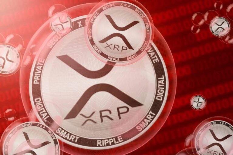 Eine physische XRP-Münze liegt auf einer Computertastatur neben einem roten Warnsymbol.