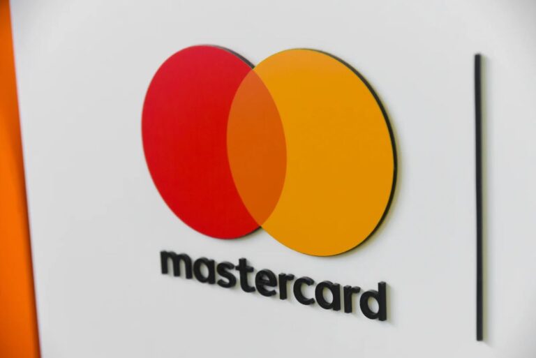 Mastercard-Logo neben dem XRP-Symbol von Ripple vor einem digitalen Finanz-Chart