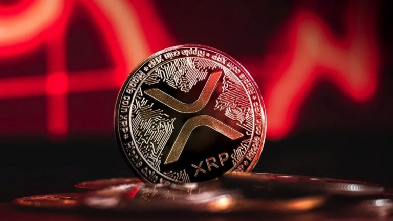 Ein fallender roter Kurs-Chart im Hintergrund einer physischen Ripple-Münze