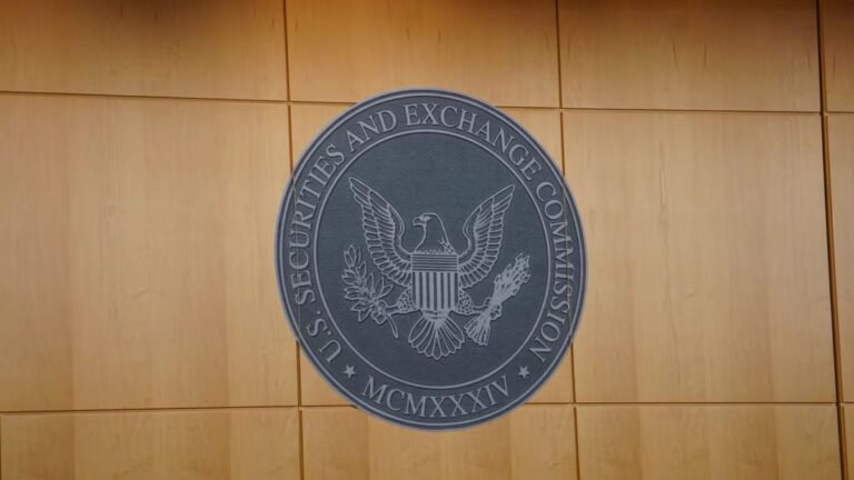 Eine physische Bitcoin-Münze auf einem Chart vor dem Logo der US-Börsenaufsicht SEC.